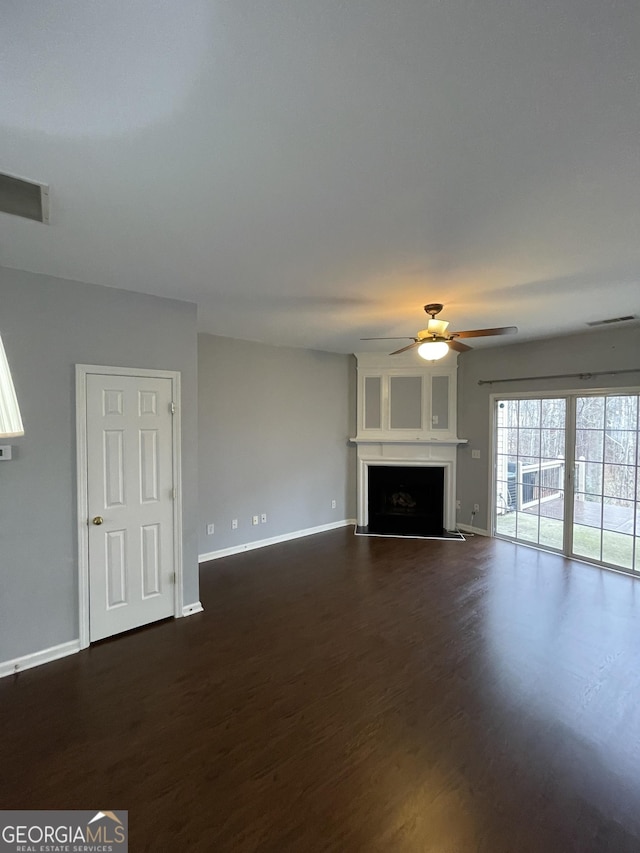 unfurnished living room with dark hardwood / wood-style floors and ceiling fan