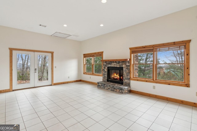 unfurnished living room with light tile patterned floors, a fireplace, and french doors