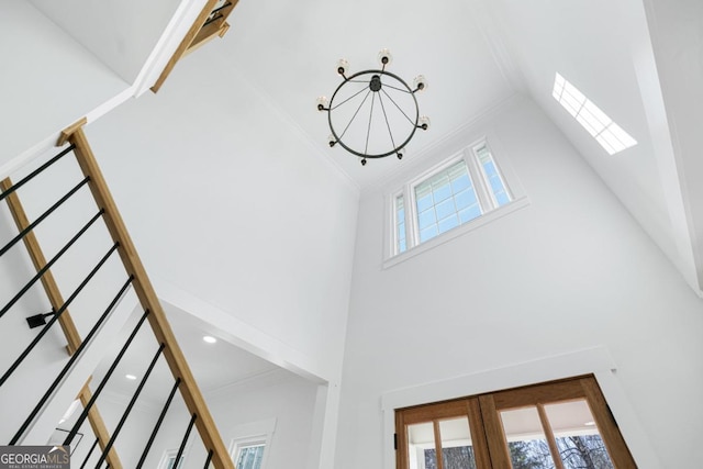 interior details with an inviting chandelier, crown molding, a skylight, and french doors