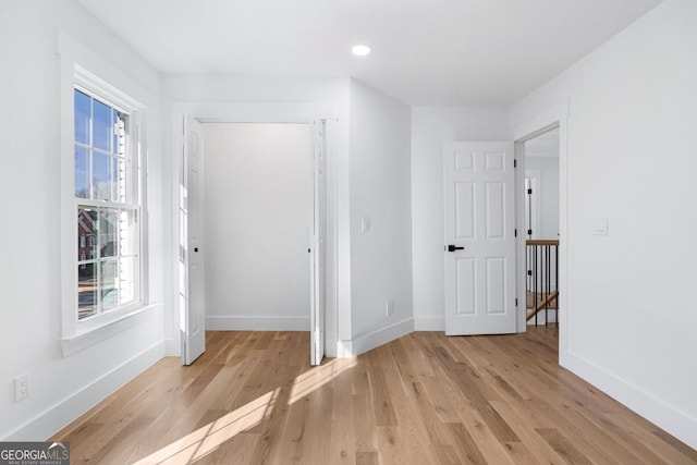 hallway with plenty of natural light and light hardwood / wood-style flooring