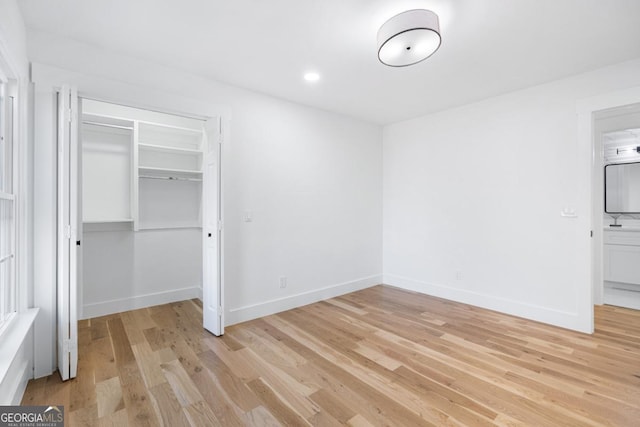 unfurnished bedroom featuring a closet and light hardwood / wood-style flooring