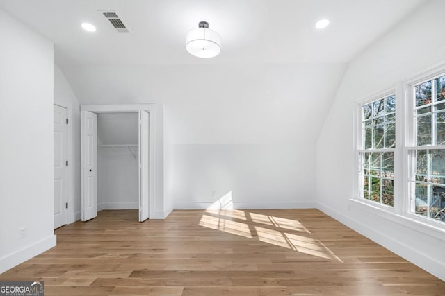 additional living space featuring lofted ceiling and hardwood / wood-style floors