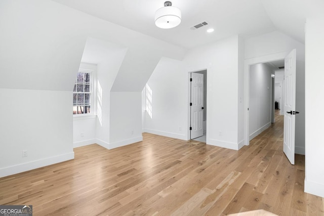 additional living space with lofted ceiling and light hardwood / wood-style flooring