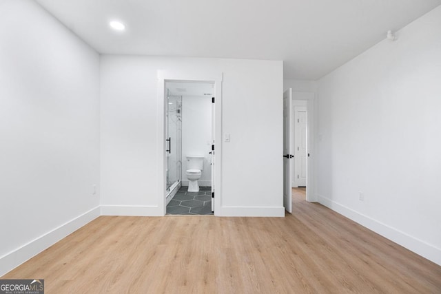 unfurnished bedroom featuring light hardwood / wood-style floors and ensuite bathroom