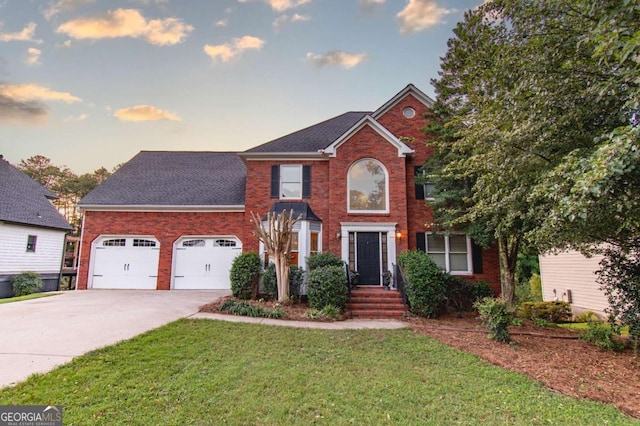 view of front of home with a garage and a yard