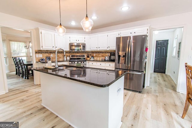 4222 Honey Creek Way, Powder Springs, GA 30127 - kitchen featuring appliances with stainless steel finishes, light wood finished floors, tasteful backsplash, white cabinetry, and dark stone countertops