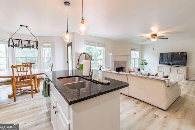4222 Honey Creek Way, Powder Springs, GA 30127 - kitchen featuring light wood-style floors, dark stone counters, a kitchen island with sink, and a ceiling fan
