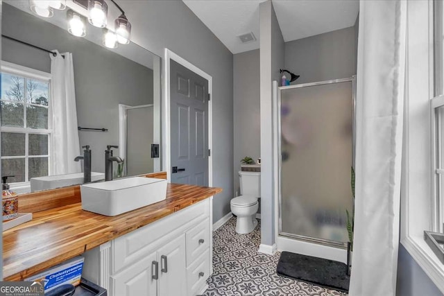 bathroom featuring walk in shower, vanity, and toilet