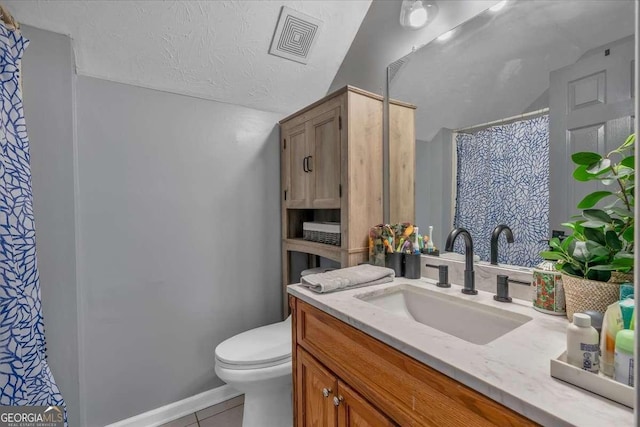 bathroom featuring vanity, tile patterned floors, a textured ceiling, and toilet