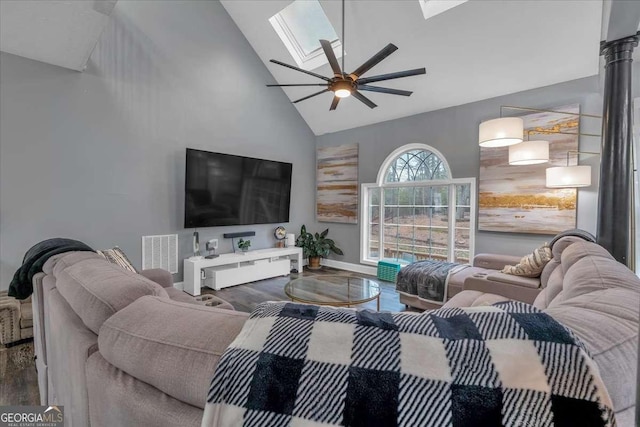 living room featuring wood-type flooring, a skylight, and high vaulted ceiling