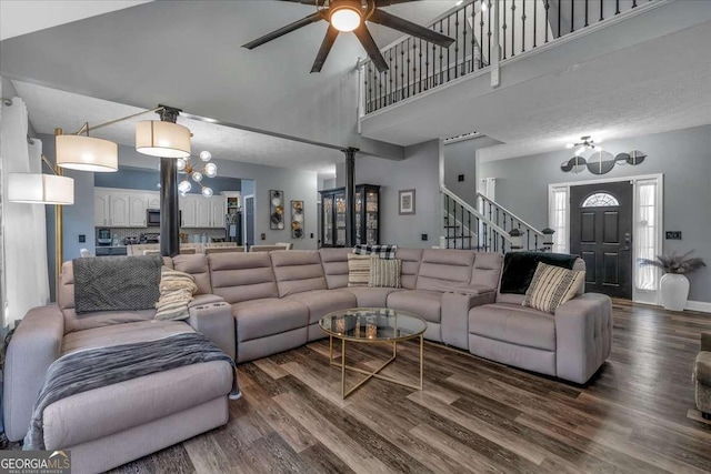 living room featuring ceiling fan, hardwood / wood-style floors, and a high ceiling