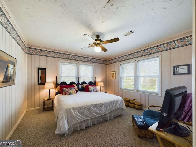 bedroom with ceiling fan, multiple windows, carpet, and a textured ceiling