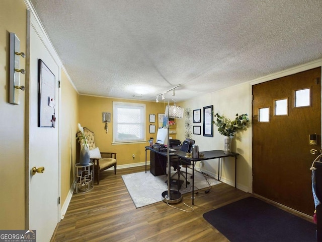 home office featuring dark wood-type flooring, crown molding, and a textured ceiling