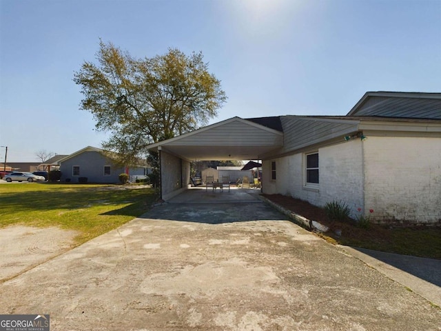 view of side of property with a carport and a yard