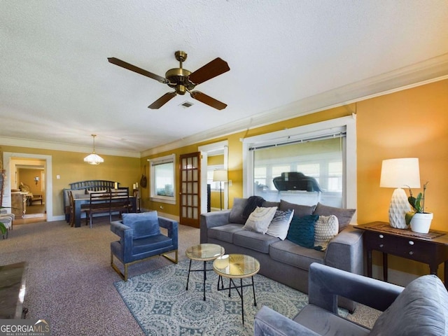 living room featuring ceiling fan, crown molding, light colored carpet, and a textured ceiling