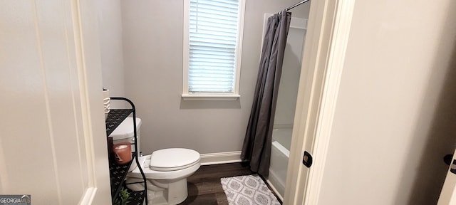 bathroom with toilet, hardwood / wood-style floors, and shower / bath combo