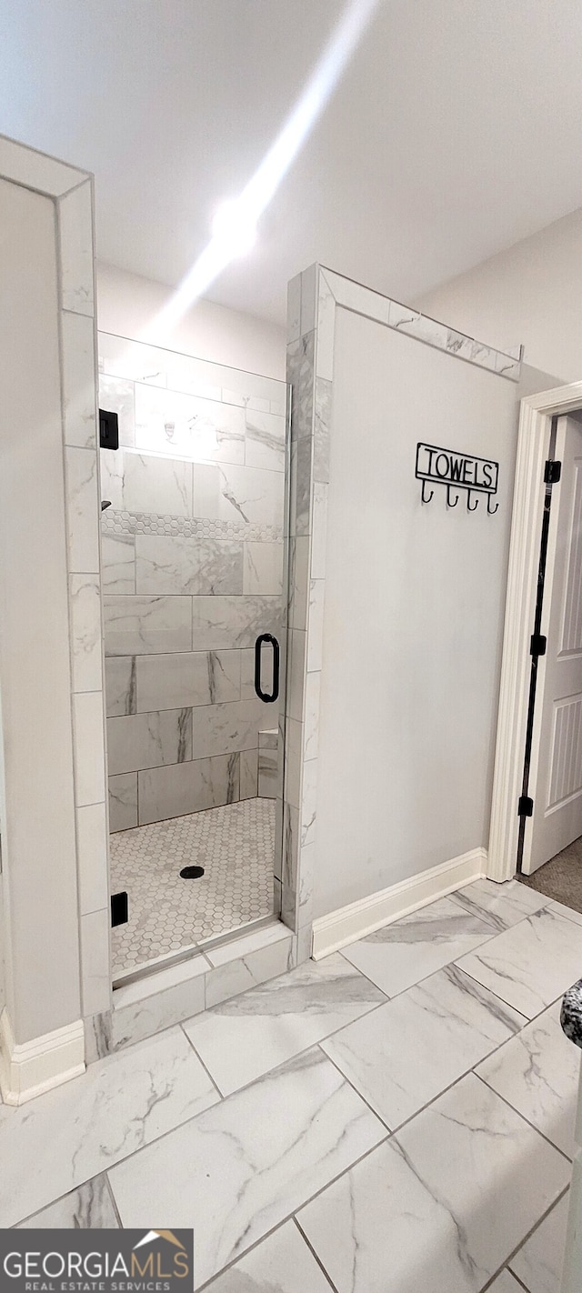 bathroom with a shower with door