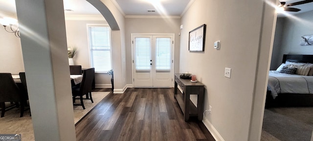 entryway with ornamental molding and dark hardwood / wood-style floors