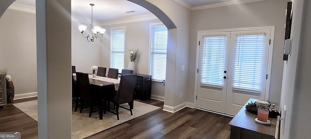 dining space featuring a healthy amount of sunlight, ornamental molding, dark hardwood / wood-style flooring, and a notable chandelier