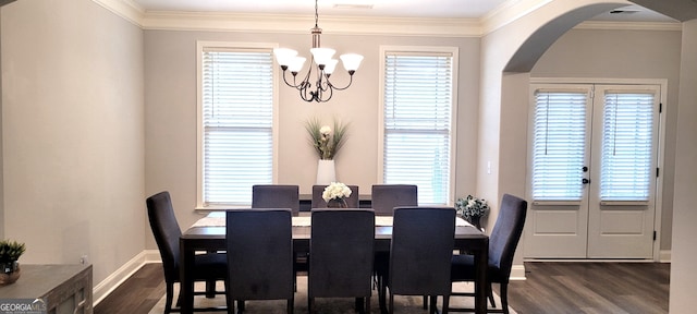 dining area featuring crown molding, an inviting chandelier, and dark hardwood / wood-style flooring