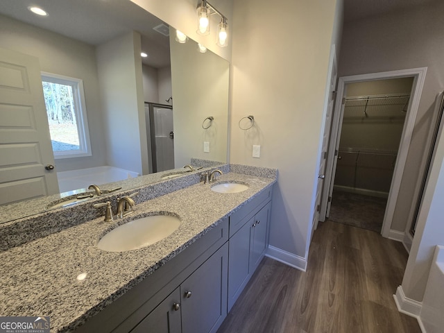 bathroom with vanity, hardwood / wood-style flooring, and independent shower and bath