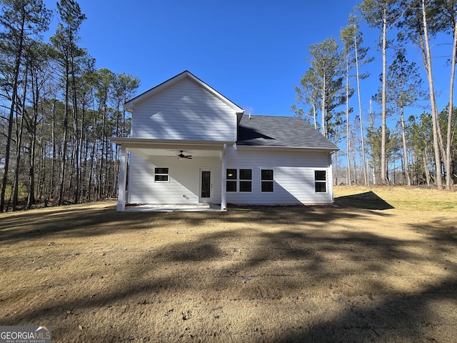 back of property with ceiling fan, a yard, and a patio