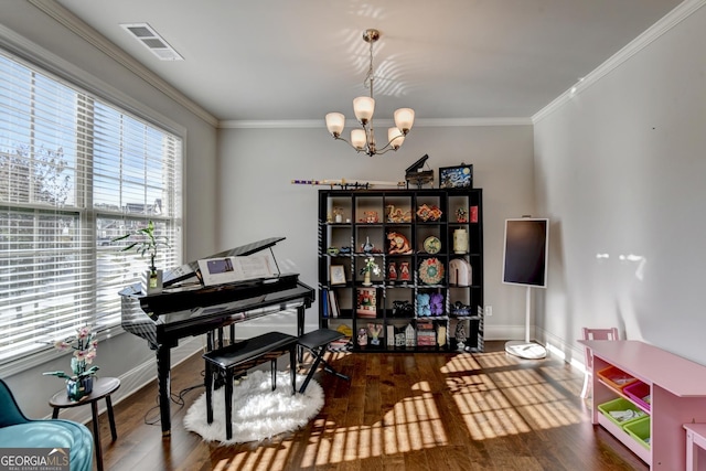 misc room with an inviting chandelier, ornamental molding, and wood-type flooring