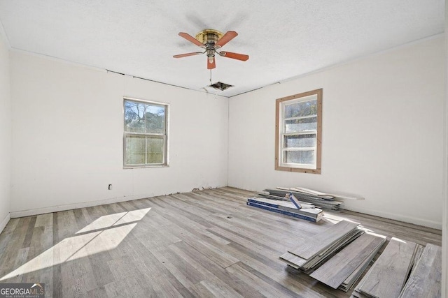 unfurnished room with plenty of natural light, ceiling fan, and light wood-type flooring