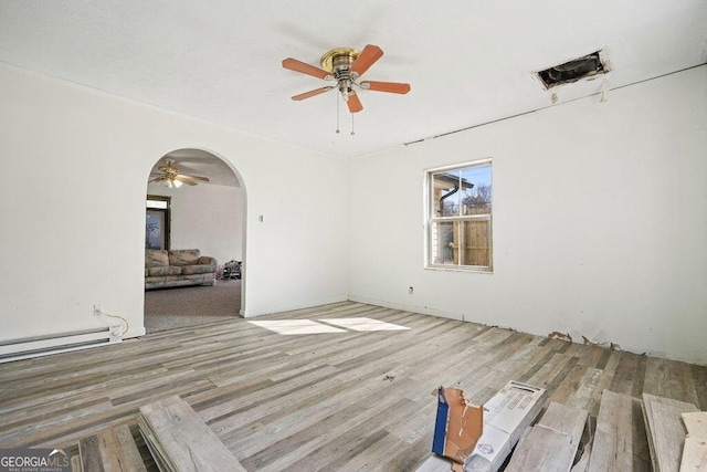 unfurnished room with baseboard heating, ceiling fan, and light hardwood / wood-style flooring