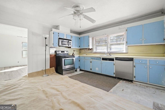 kitchen featuring sink, ceiling fan, stainless steel appliances, ornamental molding, and blue cabinets