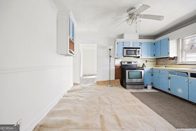 kitchen featuring ceiling fan, stainless steel appliances, ornamental molding, blue cabinets, and light colored carpet