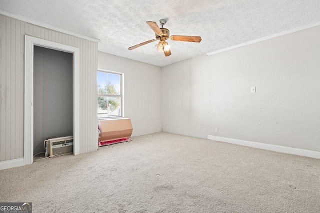 unfurnished bedroom with crown molding, ceiling fan, a wall unit AC, carpet floors, and a textured ceiling