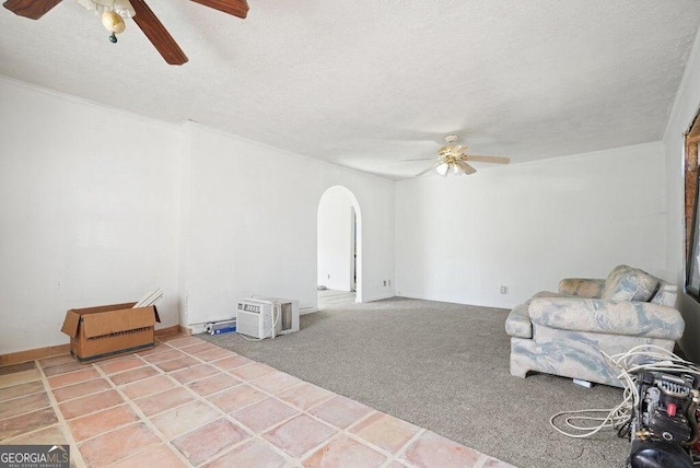 sitting room featuring ceiling fan, carpet floors, and a textured ceiling