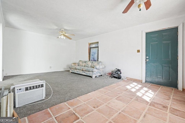 unfurnished living room featuring ceiling fan, a wall mounted AC, carpet floors, and a textured ceiling