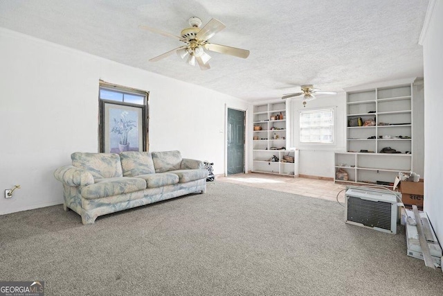 living room with ceiling fan, carpet floors, built in features, and a textured ceiling