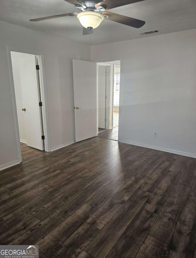 unfurnished room with ceiling fan and dark hardwood / wood-style flooring