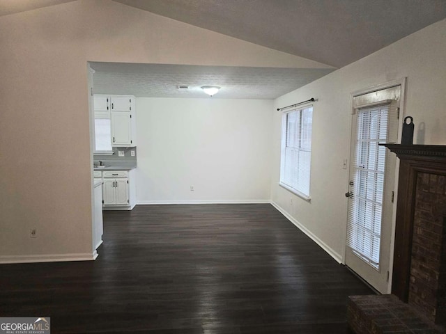 unfurnished living room with lofted ceiling and dark hardwood / wood-style flooring