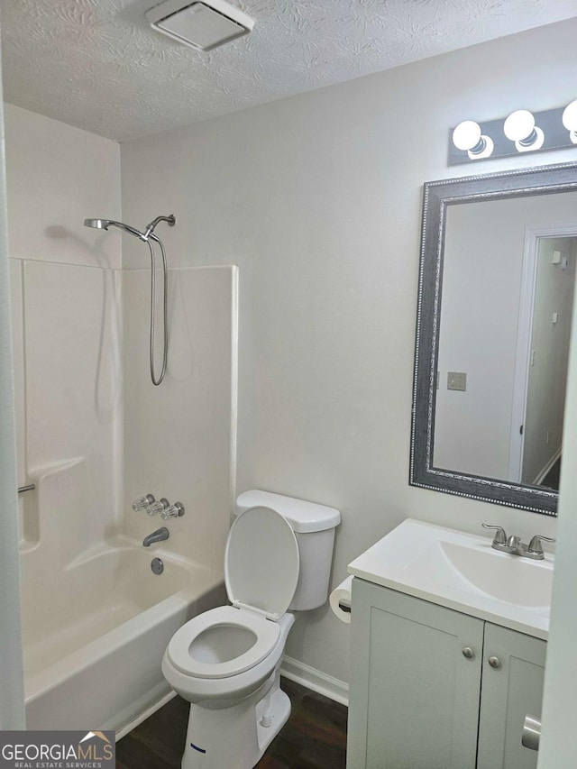 full bathroom featuring shower / washtub combination, vanity, a textured ceiling, and toilet