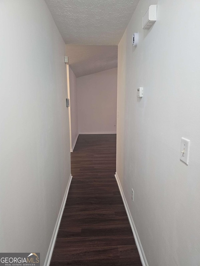 hall with dark hardwood / wood-style floors and a textured ceiling