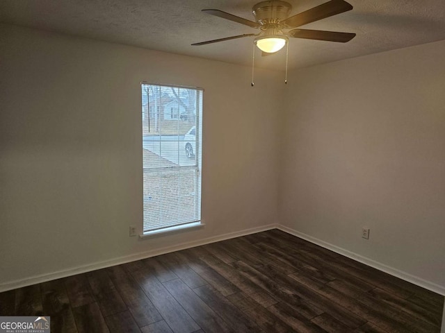 spare room featuring ceiling fan, dark wood-type flooring, and a textured ceiling