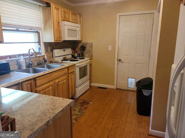 kitchen with tasteful backsplash, sink, light wood-type flooring, ornamental molding, and white appliances