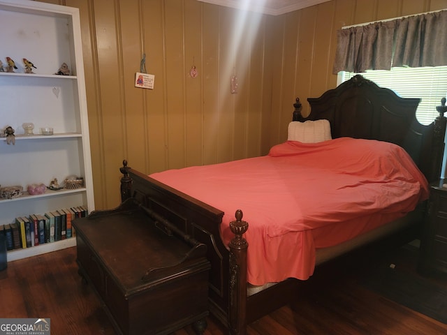 bedroom with hardwood / wood-style flooring and wooden walls