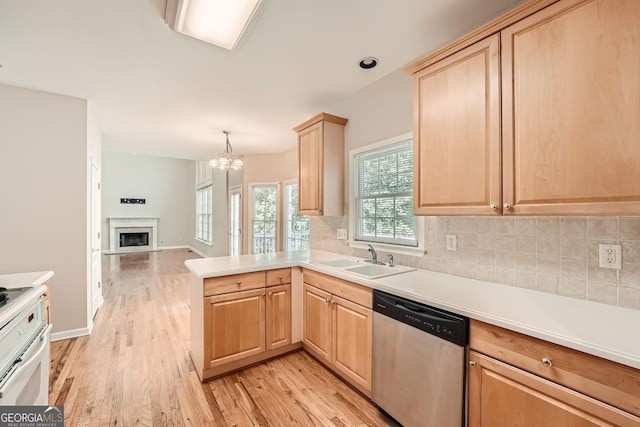 kitchen featuring dishwasher, sink, light brown cabinets, and kitchen peninsula