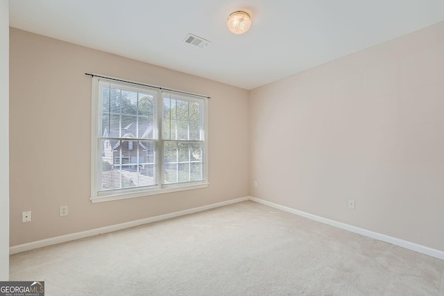 spare room featuring light carpet