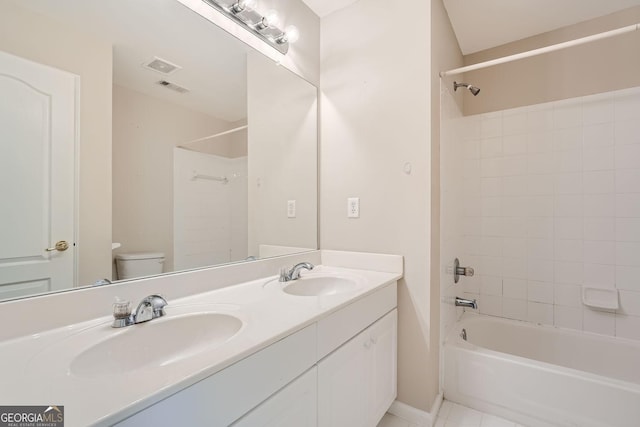 full bathroom featuring vanity, tile patterned flooring, toilet, and tiled shower / bath