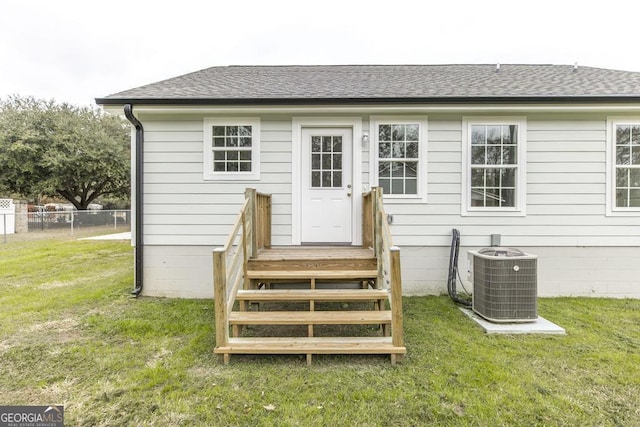 back of house with cooling unit and a yard