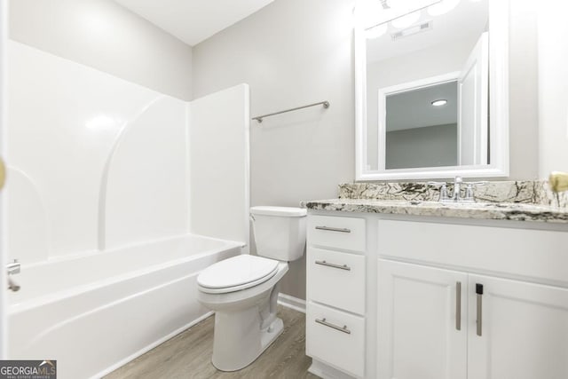 full bathroom featuring vanity, hardwood / wood-style flooring,  shower combination, and toilet