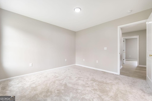 unfurnished room featuring light carpet