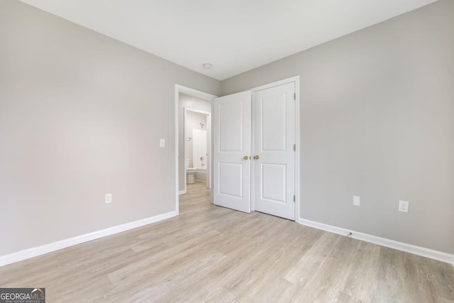 unfurnished bedroom with a closet and light hardwood / wood-style flooring