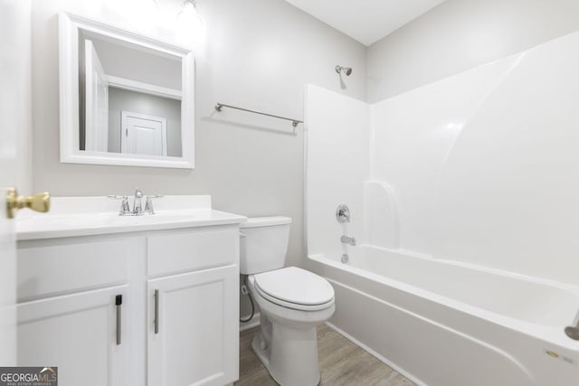 full bathroom with bathing tub / shower combination, hardwood / wood-style floors, vanity, and toilet